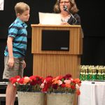 A Room 5 student excitedly waits to see his end of year award