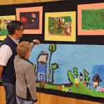 A student explores the art show with a family member