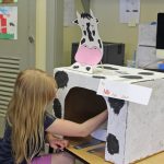 A student enjoys the Milk the Cow activity